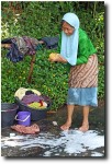 Old women wash laundry in the stream.