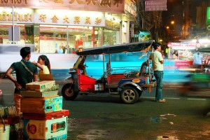 Category - Open: A tuk tuk waits for customers amid the bustle of a Bangkok Chinatown evening.