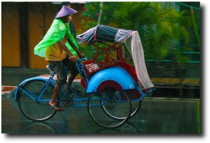 Becak driver working in the rain