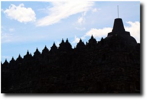 The rows of carvings and stupas are silhouetted against the sky