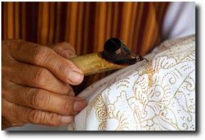 Applying wax drops to an unfinished piece of batik. Susan bought a 2-meter long piece of cloth to be made into pillow cases and such.