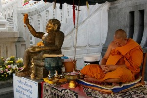 Category - Funny: A monk takes a snooze in front of Wat Traimit in Bangkok.